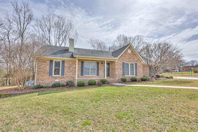 ranch-style house with a front lawn, brick siding, roof with shingles, and a chimney