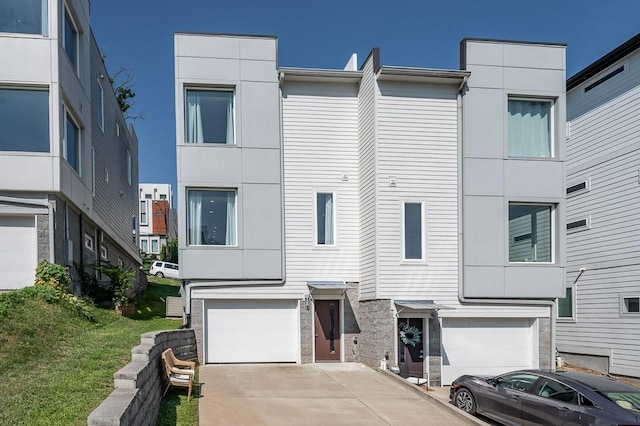 506B 36th Ave N, Nashville, TN 37209 - view of property featuring stone siding, a garage, concrete driveway, and stucco siding