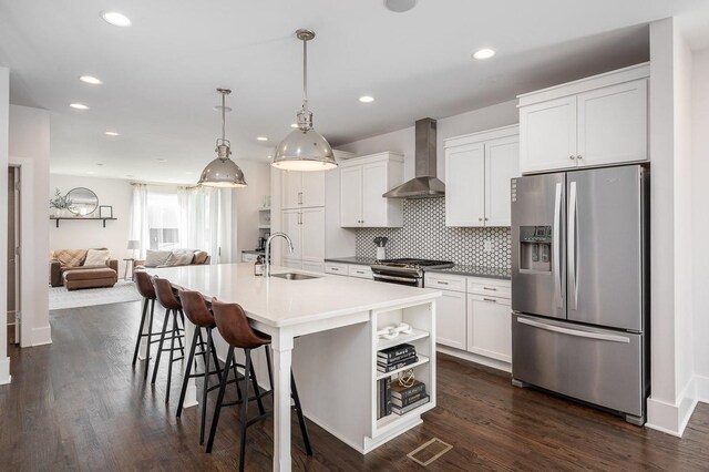 506B 36th Ave N, Nashville, TN 37209 - kitchen with appliances with stainless steel finishes, wall chimney exhaust hood, a sink, white cabinets, and a breakfast bar