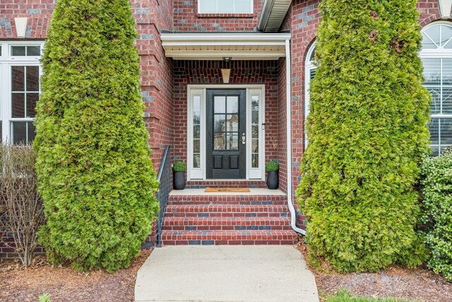 doorway to property with brick siding