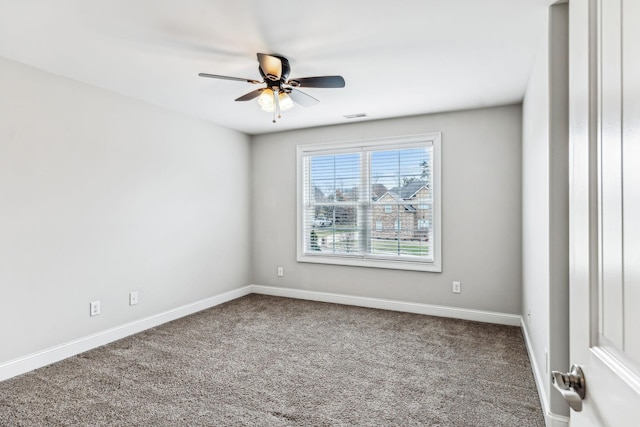 empty room featuring visible vents, carpet flooring, a ceiling fan, and baseboards