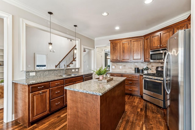 kitchen with appliances with stainless steel finishes, crown molding, dark wood-type flooring, and a sink