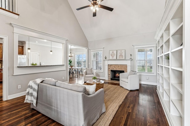 living area with baseboards, high vaulted ceiling, a fireplace, and dark wood-style flooring