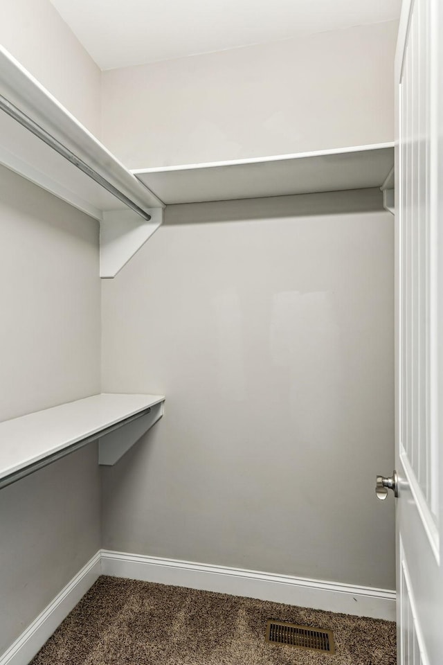 walk in closet with visible vents and dark carpet