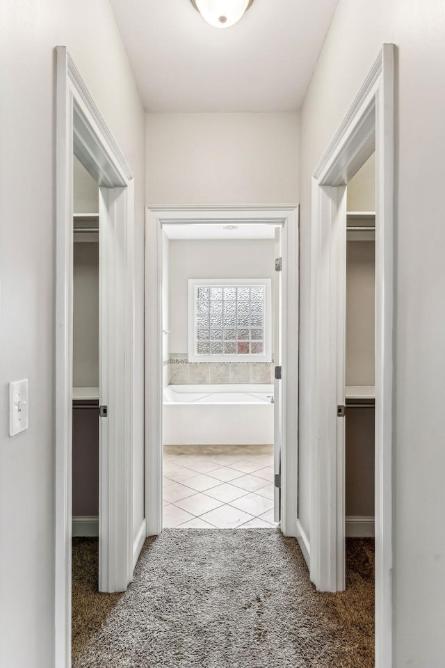 hall featuring carpet and tile patterned flooring