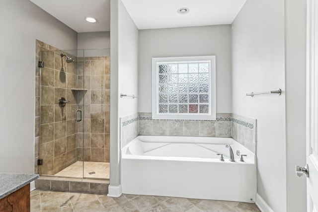 bathroom featuring tile patterned flooring, a shower stall, vanity, and a garden tub