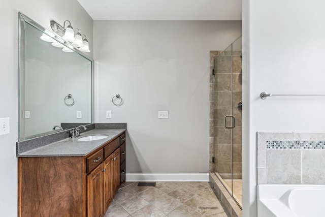 full bathroom featuring tile patterned floors, a stall shower, a bathing tub, baseboards, and vanity