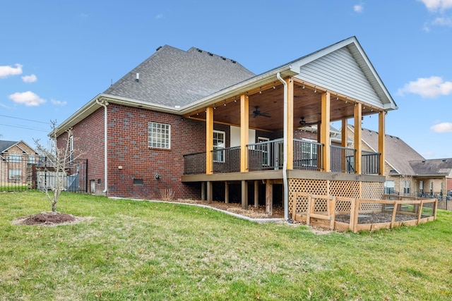 back of property featuring brick siding, a shingled roof, a lawn, crawl space, and a ceiling fan