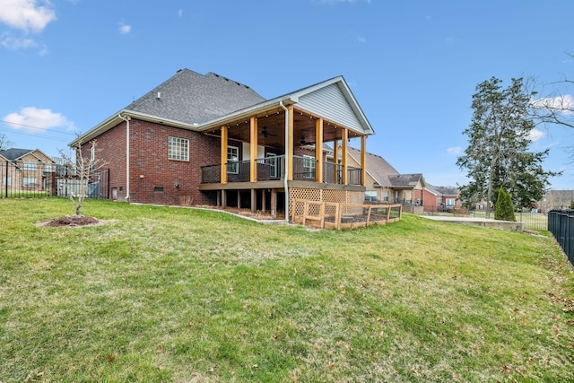 rear view of property with roof with shingles, a yard, a fenced backyard, ceiling fan, and brick siding