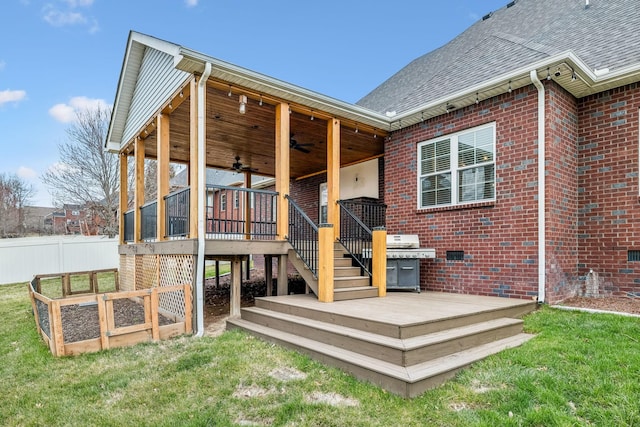 deck with stairs, a lawn, a ceiling fan, and fence