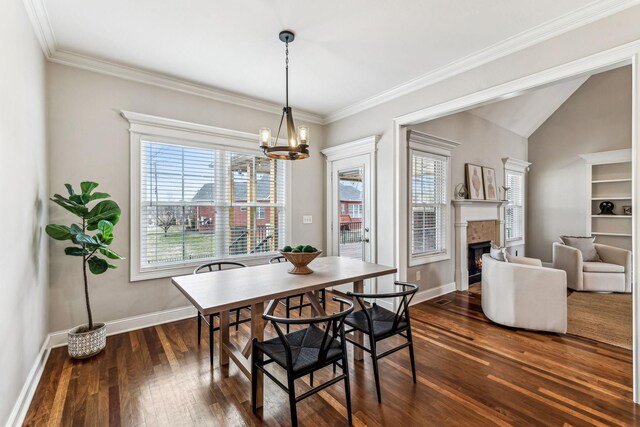 dining room with an inviting chandelier, dark wood-style floors, baseboards, and a warm lit fireplace