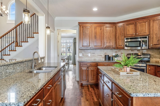 kitchen with dark wood-style floors, appliances with stainless steel finishes, light stone counters, and a sink