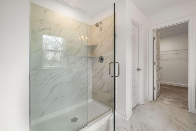 full bath with a shower stall, baseboards, marble finish floor, and a walk in closet