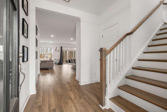 foyer with recessed lighting, stairway, baseboards, and wood finished floors