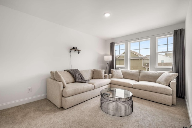 carpeted living area featuring baseboards