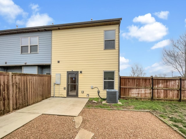 rear view of house featuring central air condition unit, a fenced backyard, and a patio area