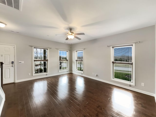 spare room featuring visible vents, baseboards, and wood finished floors