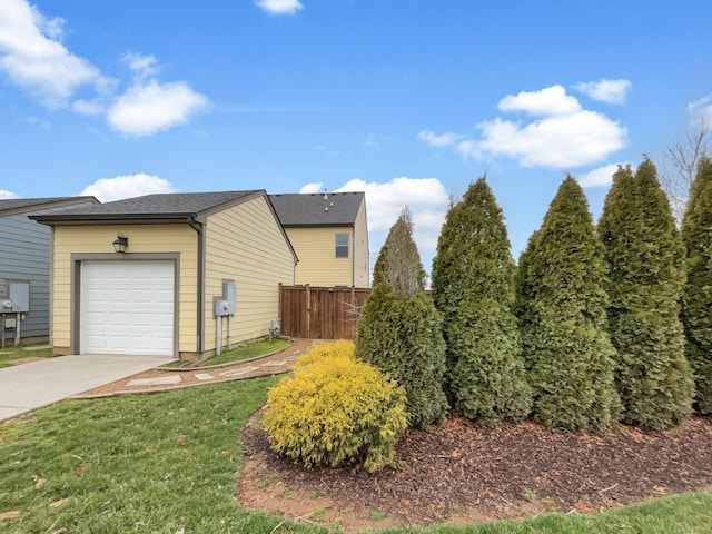 view of property exterior with concrete driveway, a yard, fence, and a garage