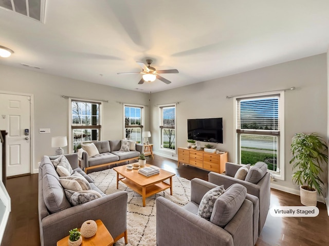 living room with visible vents, baseboards, wood finished floors, and a ceiling fan