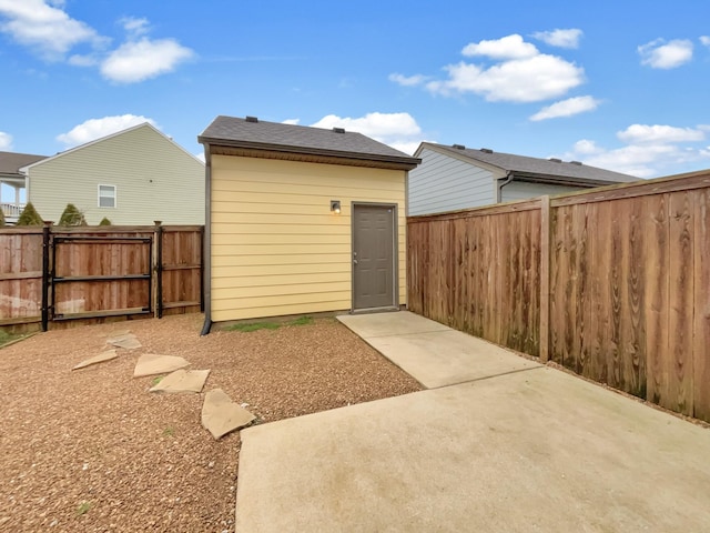 rear view of house with a patio area, a gate, and a fenced backyard