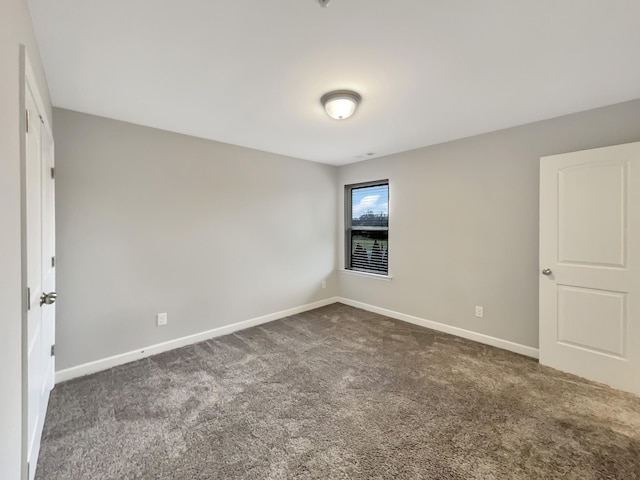 carpeted spare room with baseboards