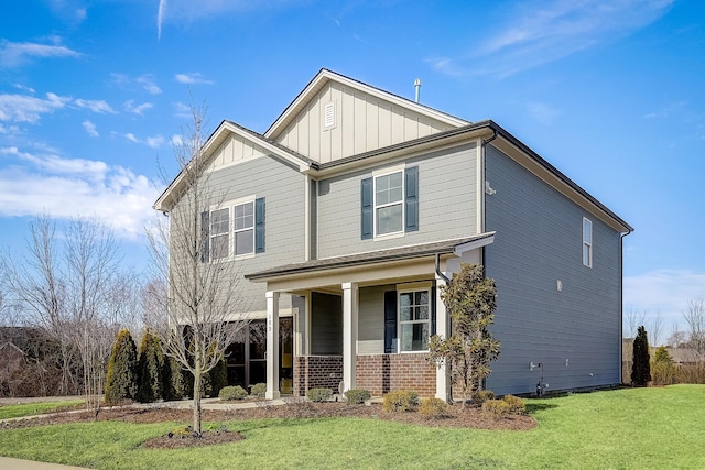 view of front of property with brick siding, board and batten siding, covered porch, and a front yard