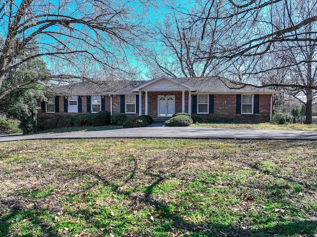 single story home with brick siding, aphalt driveway, and a front lawn