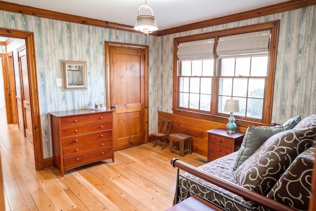 bedroom with wallpapered walls and light wood finished floors