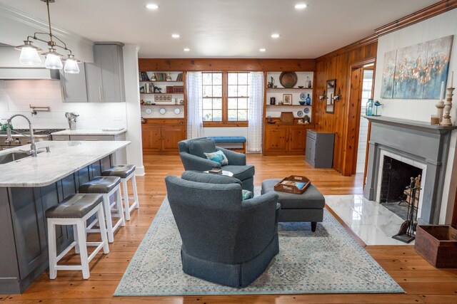 living room with recessed lighting, light wood-type flooring, and a fireplace with flush hearth