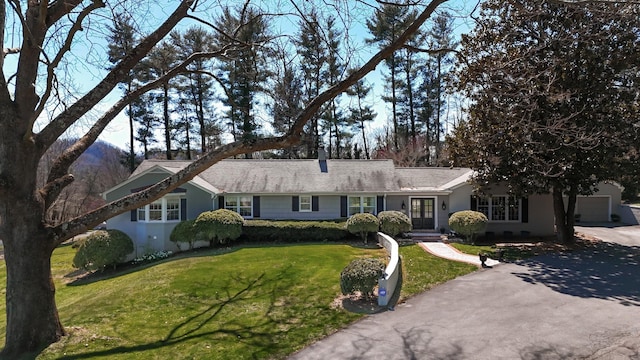 single story home with a front lawn and aphalt driveway