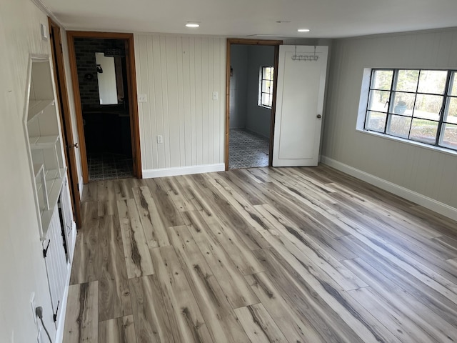 spare room with light wood-style flooring, plenty of natural light, and baseboards