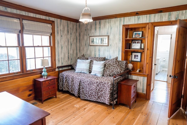 bedroom with wallpapered walls and light wood finished floors