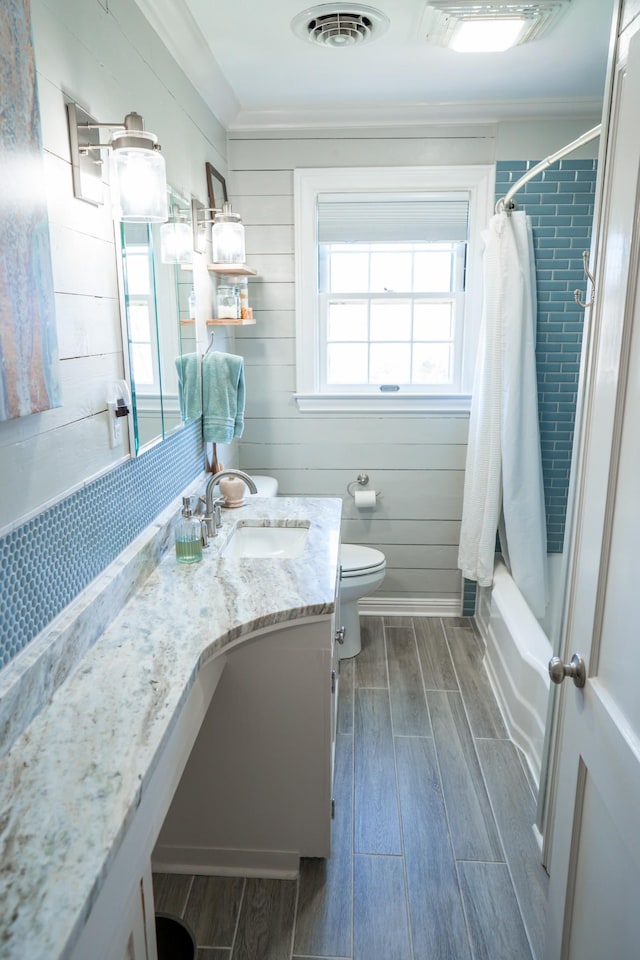 bathroom with wood finish floors, visible vents, toilet, shower / bath combo, and vanity