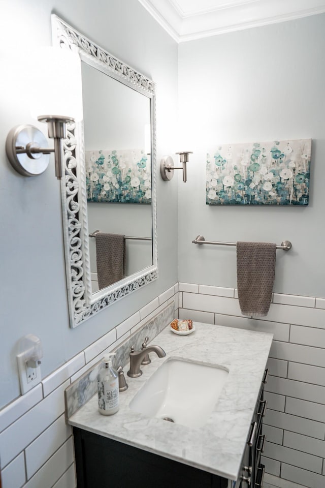 bathroom featuring wainscoting, vanity, tile walls, and crown molding