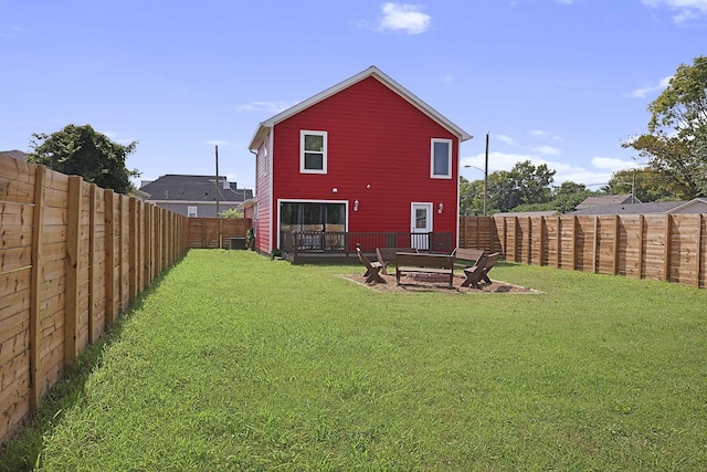 back of house with a yard and a fenced backyard