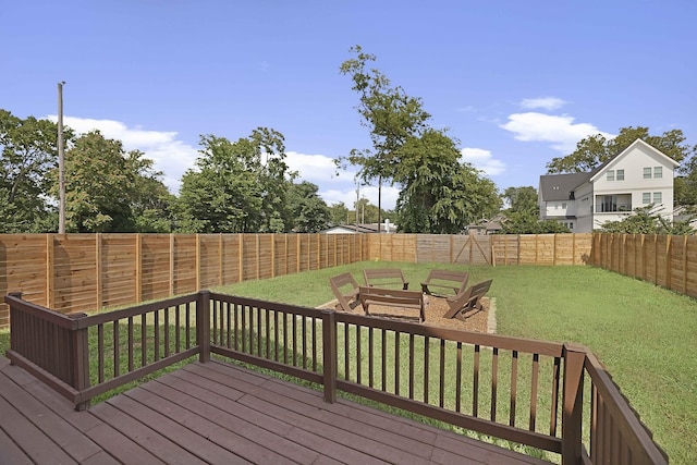 wooden terrace featuring a lawn and a fenced backyard