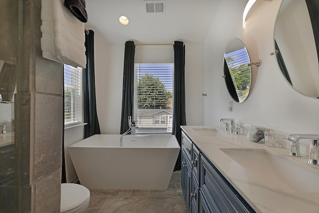 bathroom with a soaking tub, visible vents, toilet, and a sink