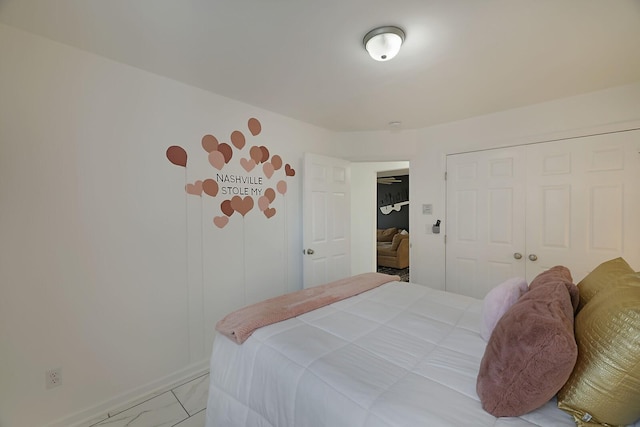 bedroom with a closet and marble finish floor