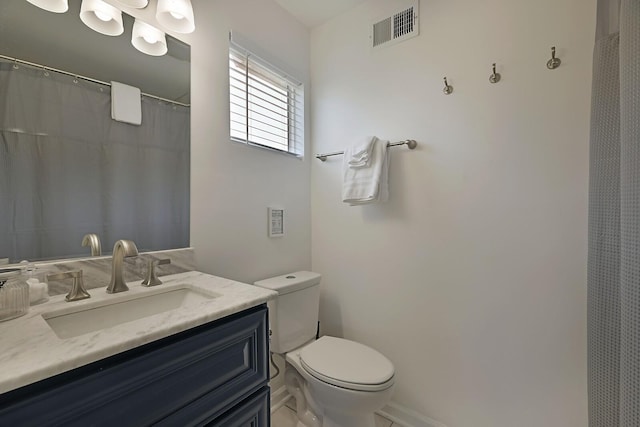 bathroom with vanity, toilet, baseboards, and visible vents