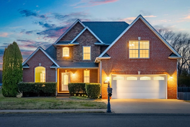 view of front of property with an attached garage, brick siding, stone siding, and driveway