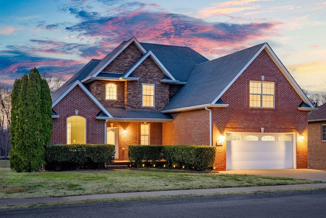 view of front of property with a front lawn, stone siding, concrete driveway, a garage, and brick siding