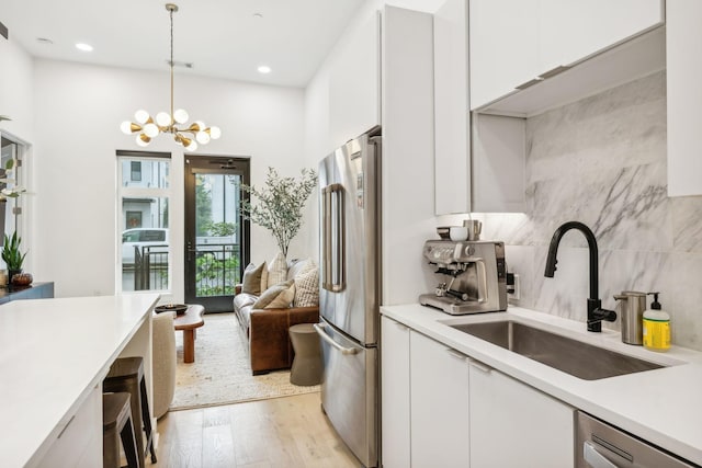 kitchen featuring light countertops, white cabinets, appliances with stainless steel finishes, and a sink