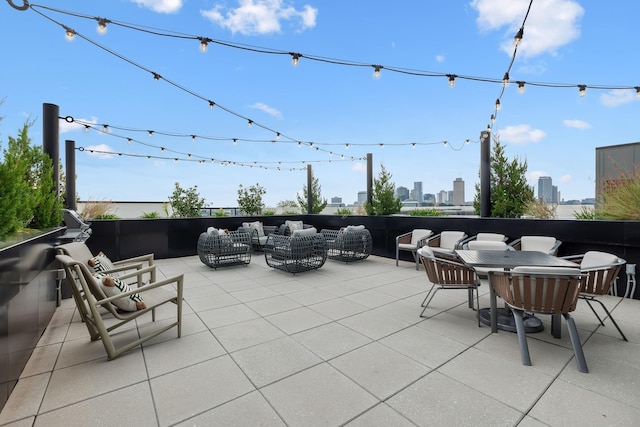 view of patio / terrace with an outdoor living space, outdoor dining area, and a city view