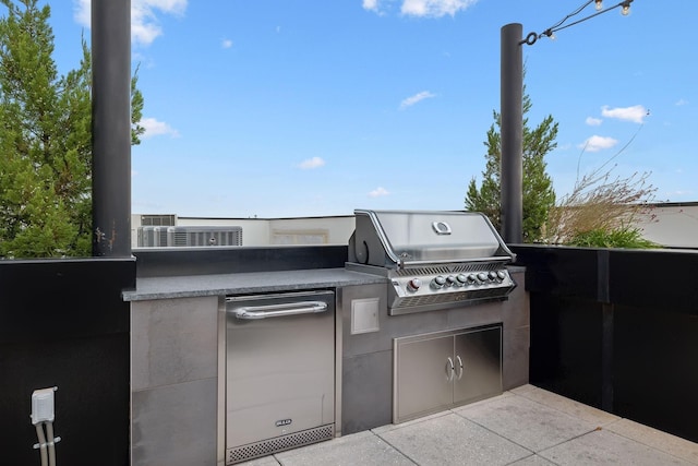 view of patio featuring exterior kitchen and a grill