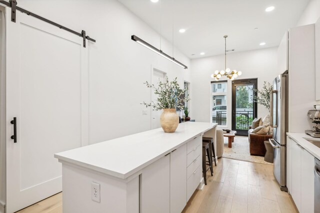 kitchen featuring a barn door, recessed lighting, light wood-style floors, and a kitchen island