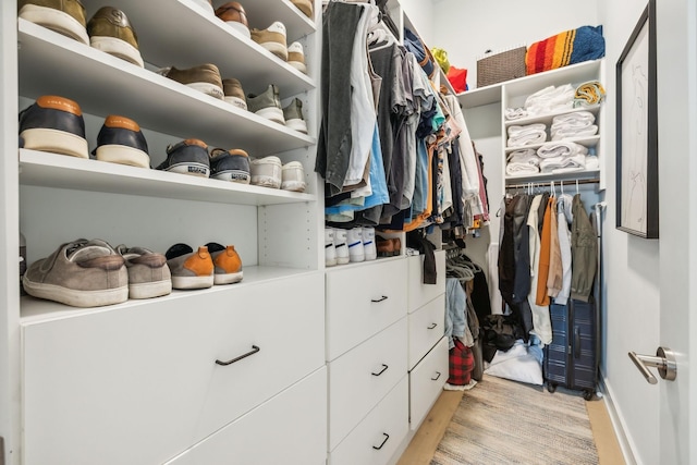 walk in closet with light wood-style flooring