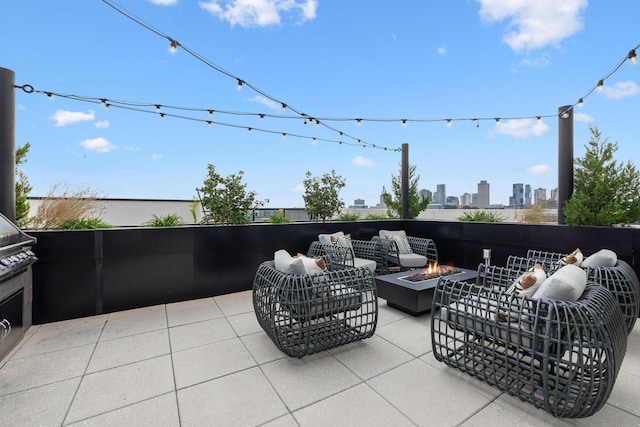 view of patio / terrace with a city view and an outdoor living space with a fire pit