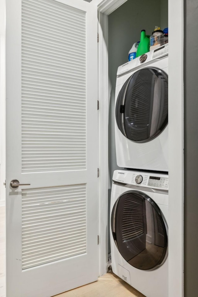 clothes washing area featuring laundry area and stacked washer and clothes dryer