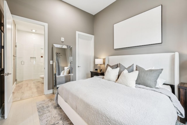 bedroom featuring light wood-style flooring and ensuite bathroom