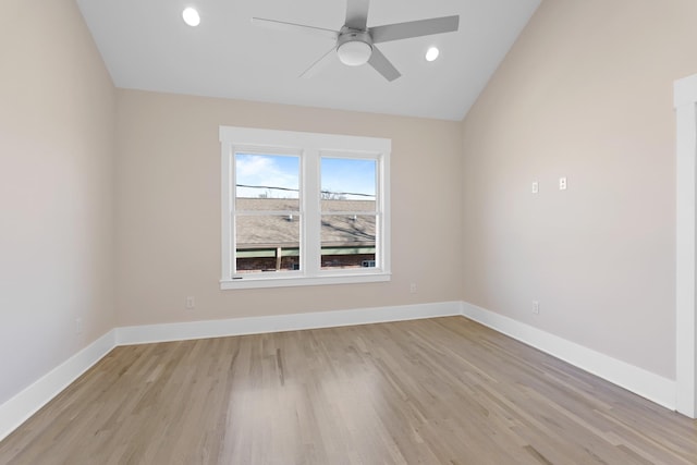 spare room with vaulted ceiling, baseboards, and light wood-type flooring